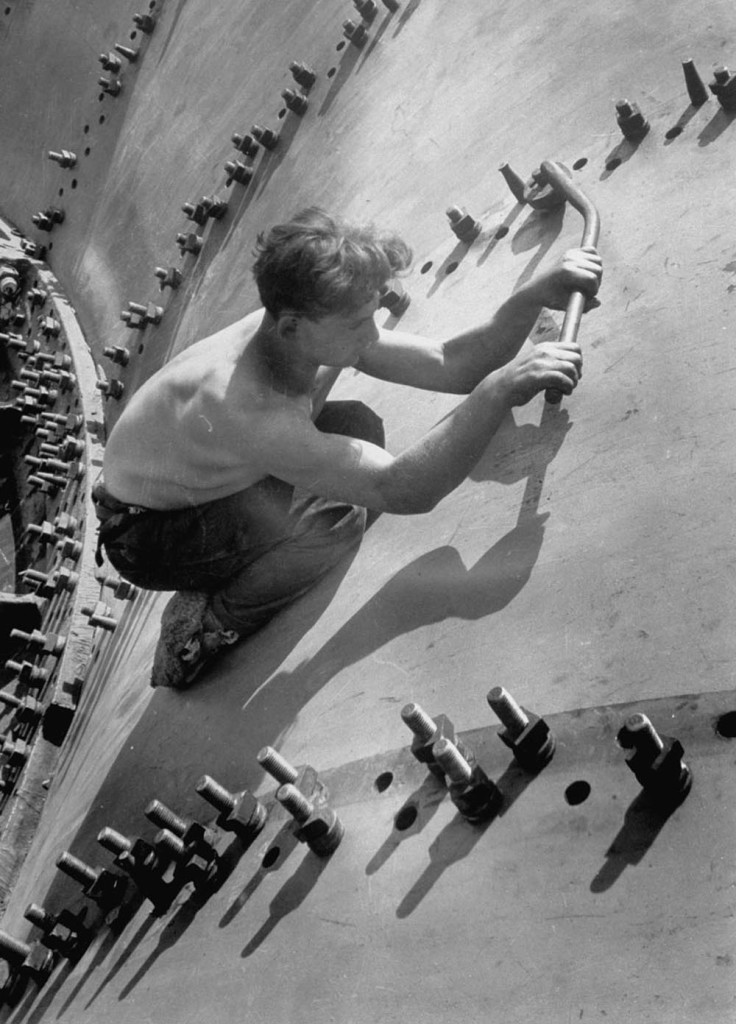 Circa 1930: Russian worker using large wrench to tighten nut on of the huge bolts used in the construction of a generator shell for the Dnieper River Dam.  (Photo by Margaret Bourke-White/Time & Life Pictures/Getty Images)