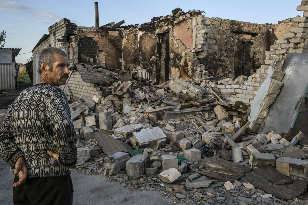 Vasiliy Goncharov outside the rubble of his home, destroyed during recent clashes between Ukrainian and pro-Russian forces, in Ilovaysk, Sept. 3, 2014. A recent devastating offensive mounted by Russian artillery units at the end of August has routed government forces, breaking what had been a relentless advance that had seemed on the verge of crushing the pro-Russian uprising in the country’s southeast.  (Mauricio Lima/The New York Times)