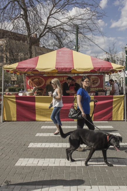 A straight-on shot of a yellow and red stripped food stand selling blooming onions.