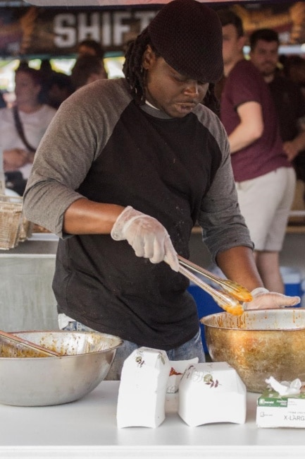 A man coats wings in hot sauce at Wing Fest 2018