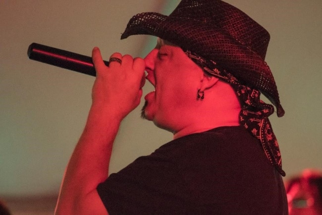 The vocalist for band Under the Gun is lit up in red stage lights during a performance at Wing Fest 2018